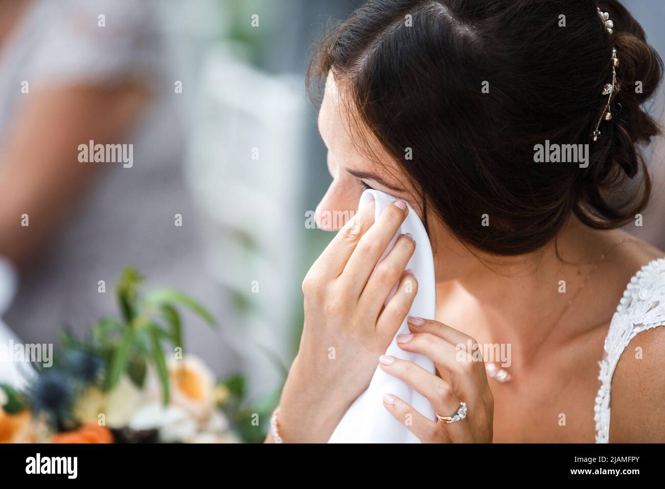 Die Braut weint glücklich am Tisch. Stockfoto