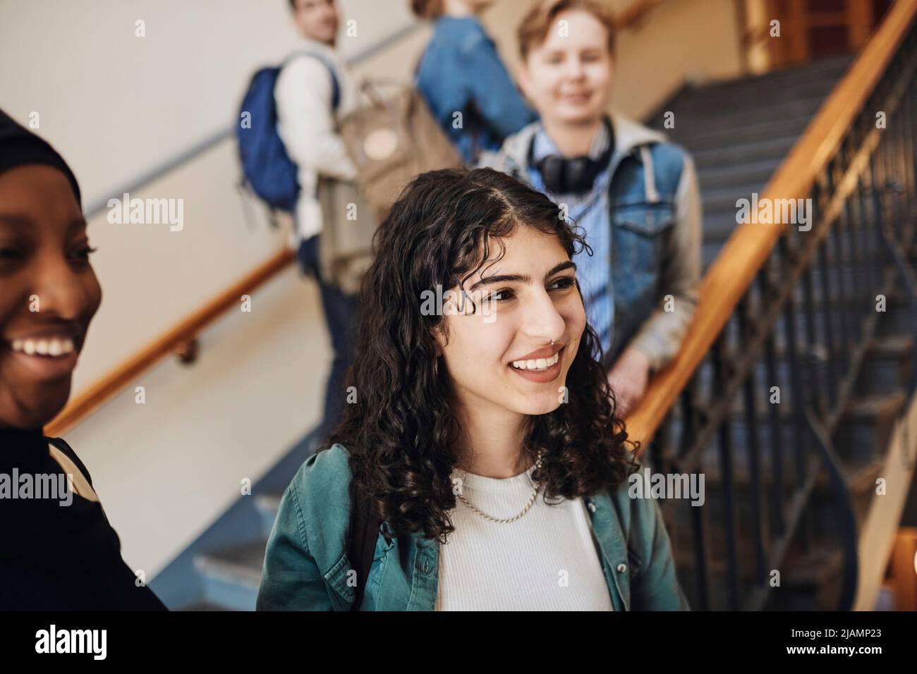 Lächelnde Studentinnen, die auf die Treppe in der Universität blicken Stockfoto