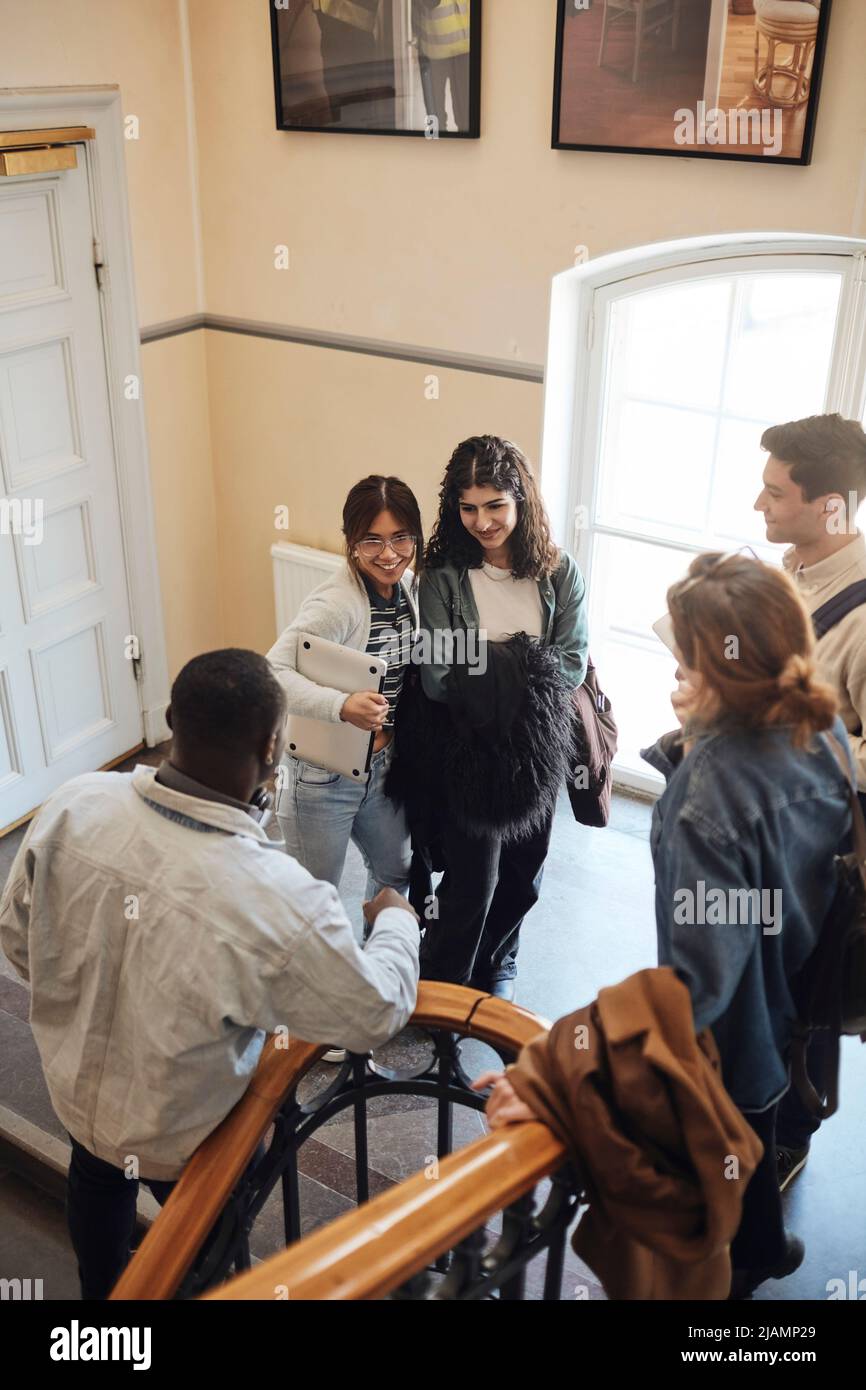 Blick aus der Perspektive von multirassischen Studenten, die sich im Treppenhaus der Universität unterhalten Stockfoto
