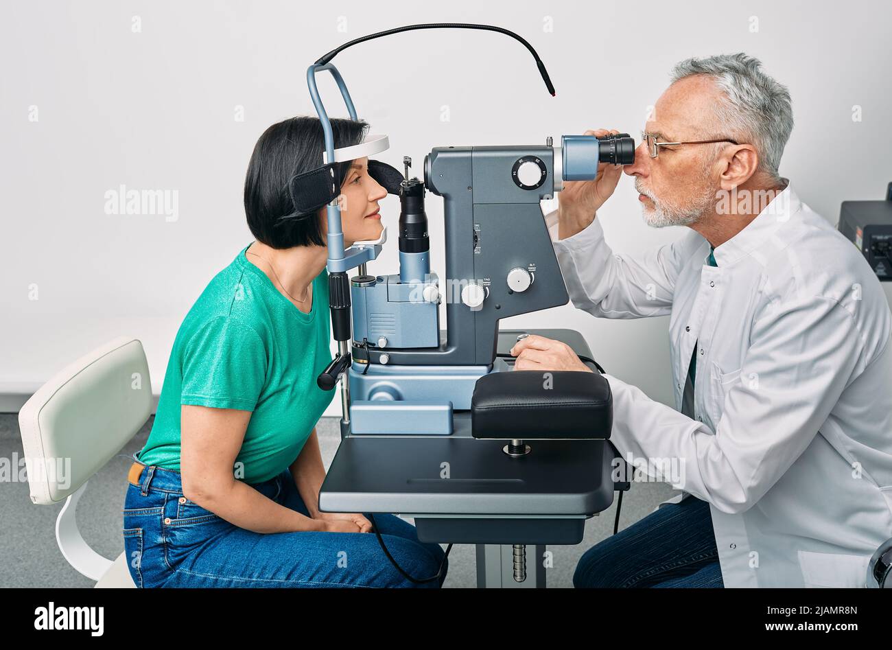 Augenheilkunde. Frau, die in der Augenklinik mit einem erfahrenen Optiker einen Visumtest mit binokulärer Spaltlampe erhält Stockfoto