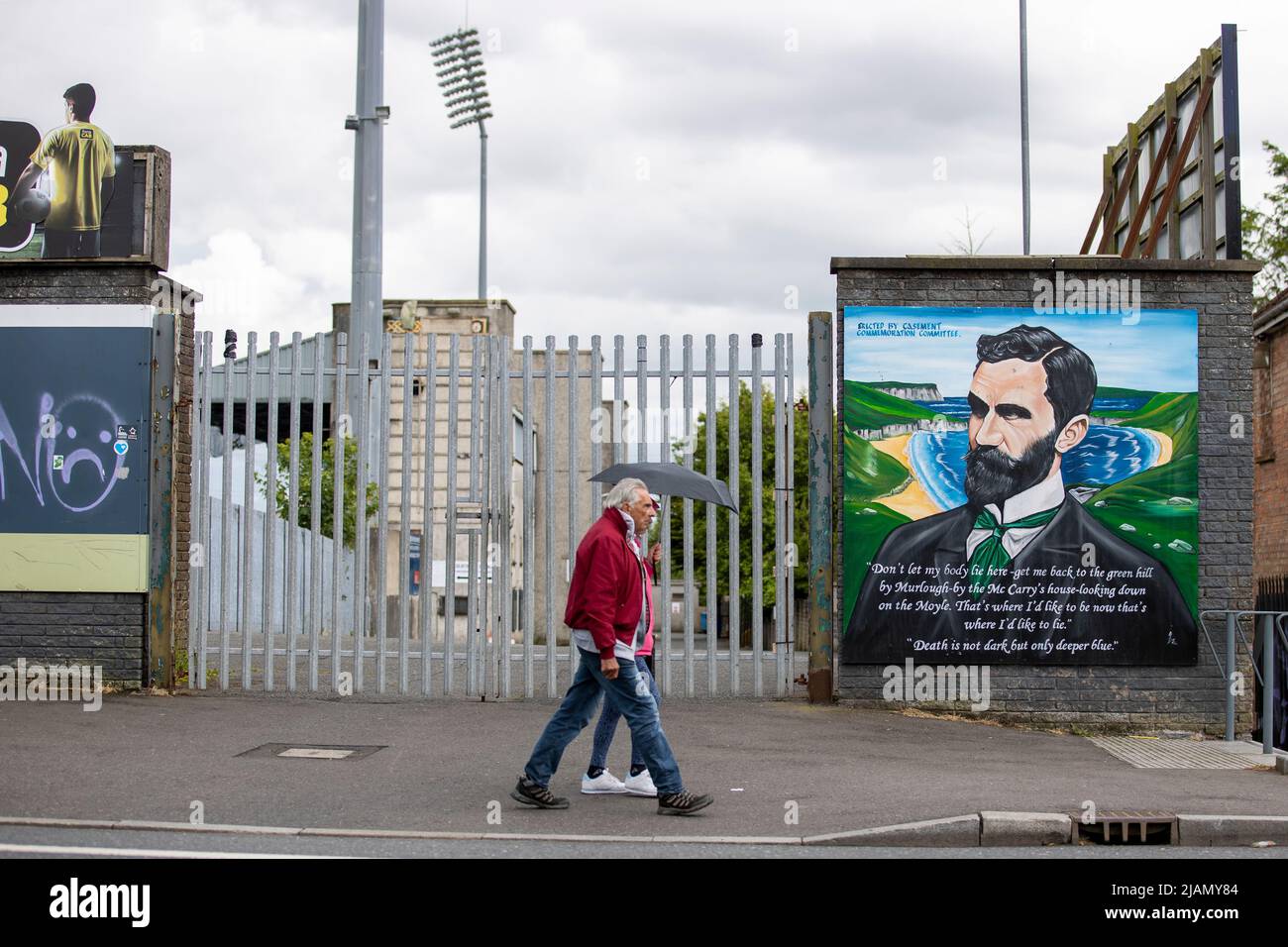 Menschen, die am Casement Park, dem wichtigsten gälischen Spielstadion in Belfast, Nordirland, vorbeilaufen. Eine Klage einer Anwohnergruppe gegen eine Entscheidung, die Baugenehmigung für die Sanierung des Casement Park der GAA in Belfast zu erteilen, wurde abgewiesen. Bilddatum: Dienstag, 31. Mai 2022. Stockfoto