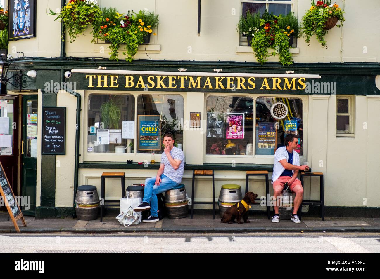 Zwei Männer entspannen sich an den Straßentischen vor dem beliebten Pub The Basketmakers Arms in Brighton's North Laine. Stockfoto