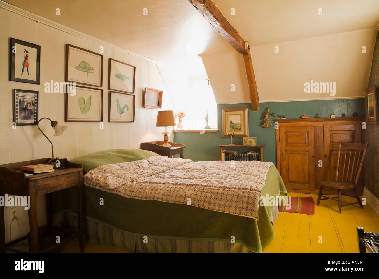 Doppelbett mit karierten Bettüberwürfen und antiken Möbeln im Hauptschlafzimmer im Obergeschoss im alten, ca. 1810 Jahre alten Haus im kanadischen Cottage-Stil. Stockfoto