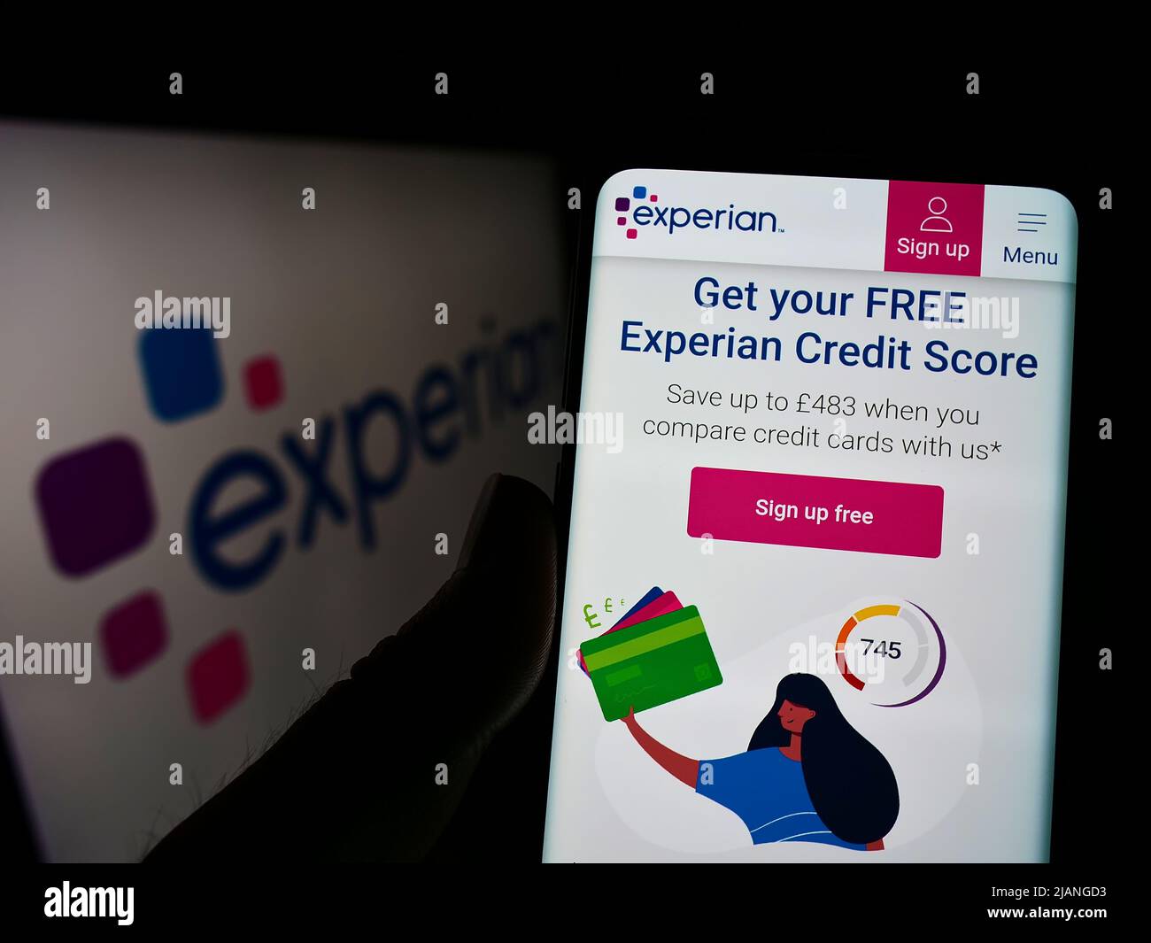 Person, die Mobiltelefon mit der Website des Kreditausstellers Experian plc auf dem Bildschirm vor dem Logo hält. Konzentrieren Sie sich auf die Mitte des Telefondisplays. Stockfoto