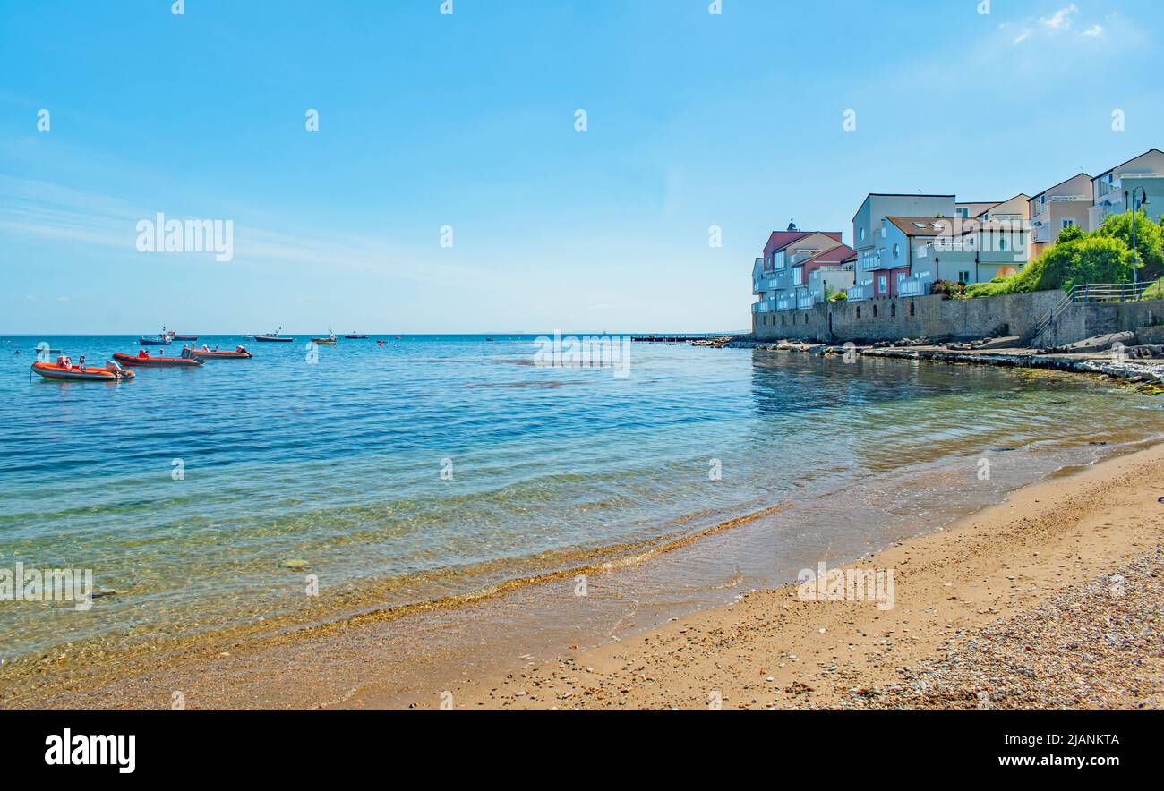 Der Sandstrand und Boote auf einem blauen Meer in der Nähe von Peveril Point Swanage England an einem hellen Maitag Stockfoto