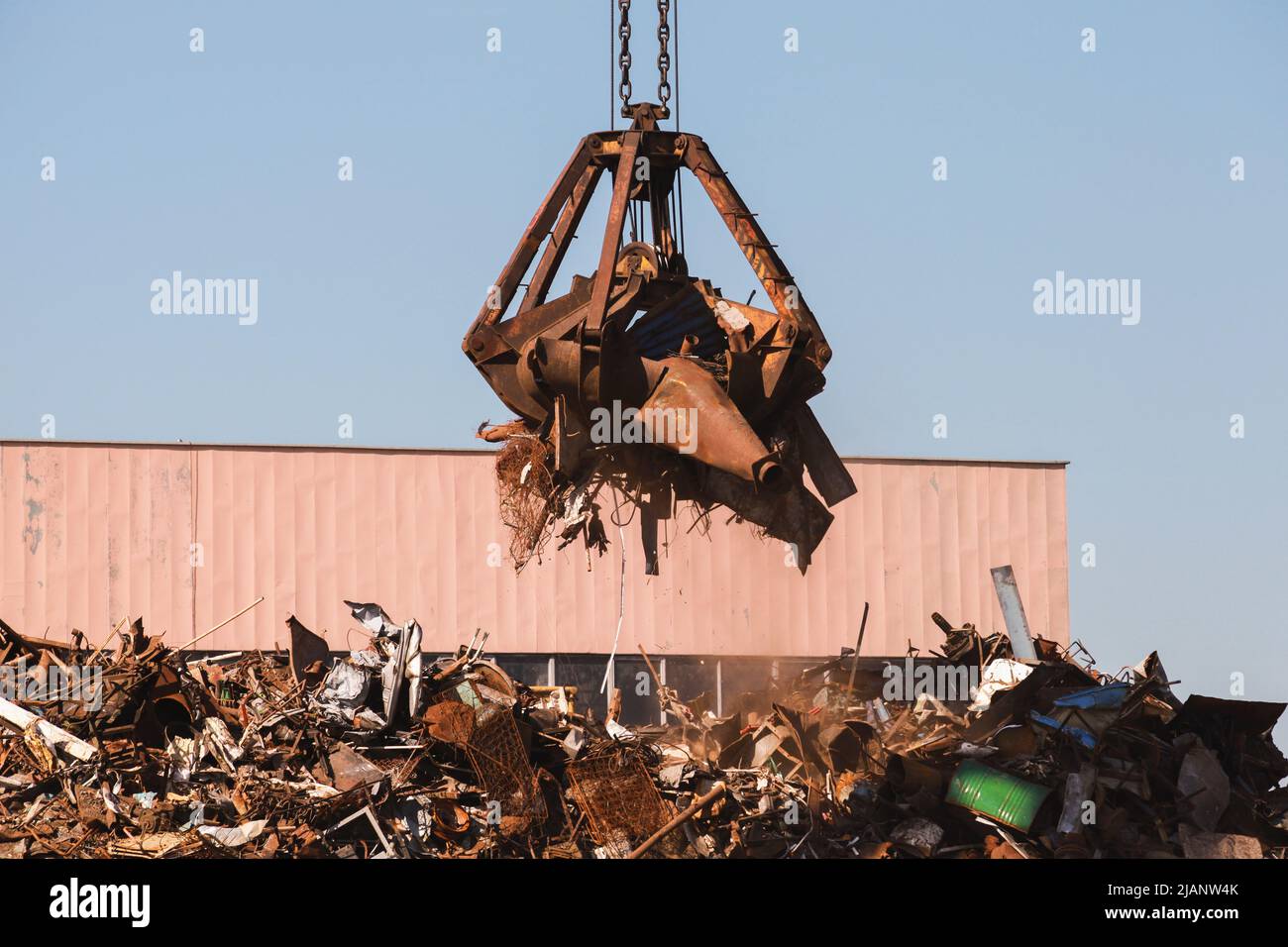 Hydraulikgreifer voll rostigen Metallschrott zum Recycling. Hafenkran Stockfoto