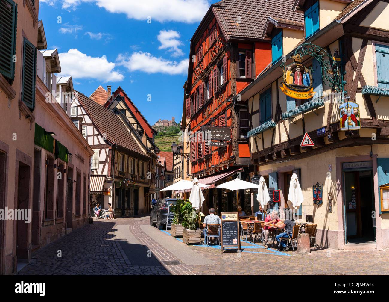 Ribeauville, Frankreich - 30. Mai 2022: In einem Straßencafé im historischen Dorfzentrum von Riebauville genießen die Menschen Getränke und eine Mahlzeit Stockfoto