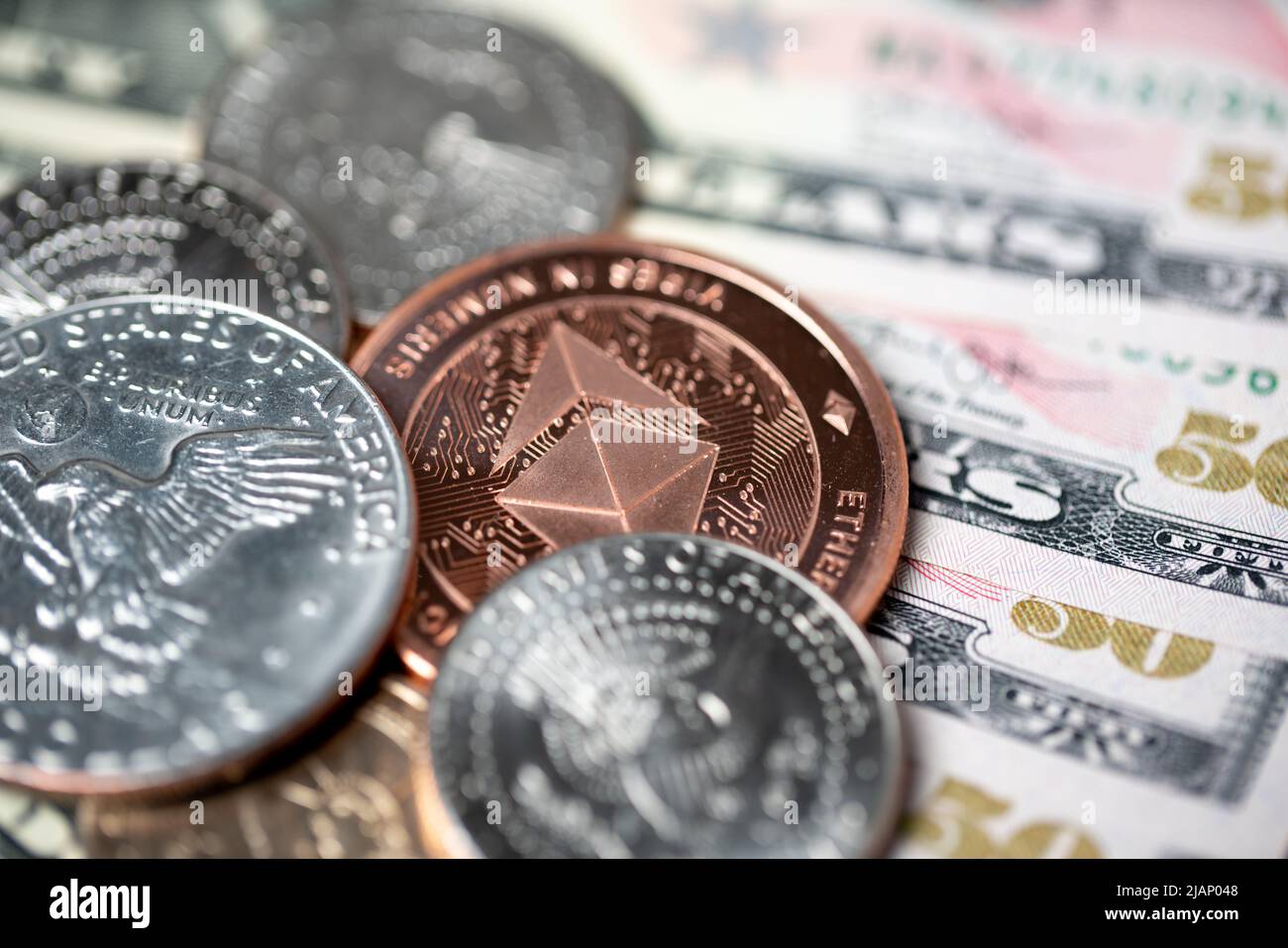 Kupfer-Ethereum-Münze auf Dollar-Banknoten und -Münzen. Eisenhower-Dollar neben dem ETH-Währungskonzept. Stockfoto