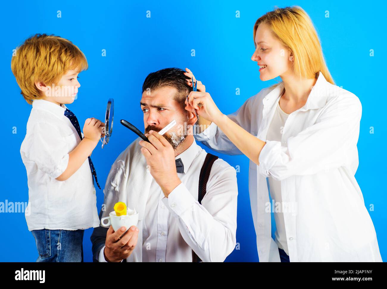Assistent für Papa. Vatertag. Mann, der sich den Bart rasieren lässt. Kleiner Barbier. Zeit mit der Familie. Barbershop-Konzept. Stockfoto