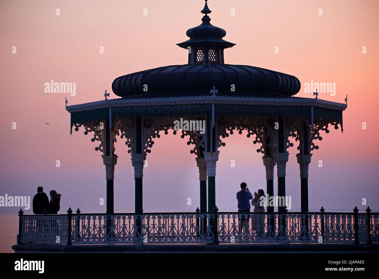 Brighton's Victorian Bandstand. Brighton & Hove, East Sussex, England. Dunkel-rosa Himmel in der Dämmerung. Stockfoto