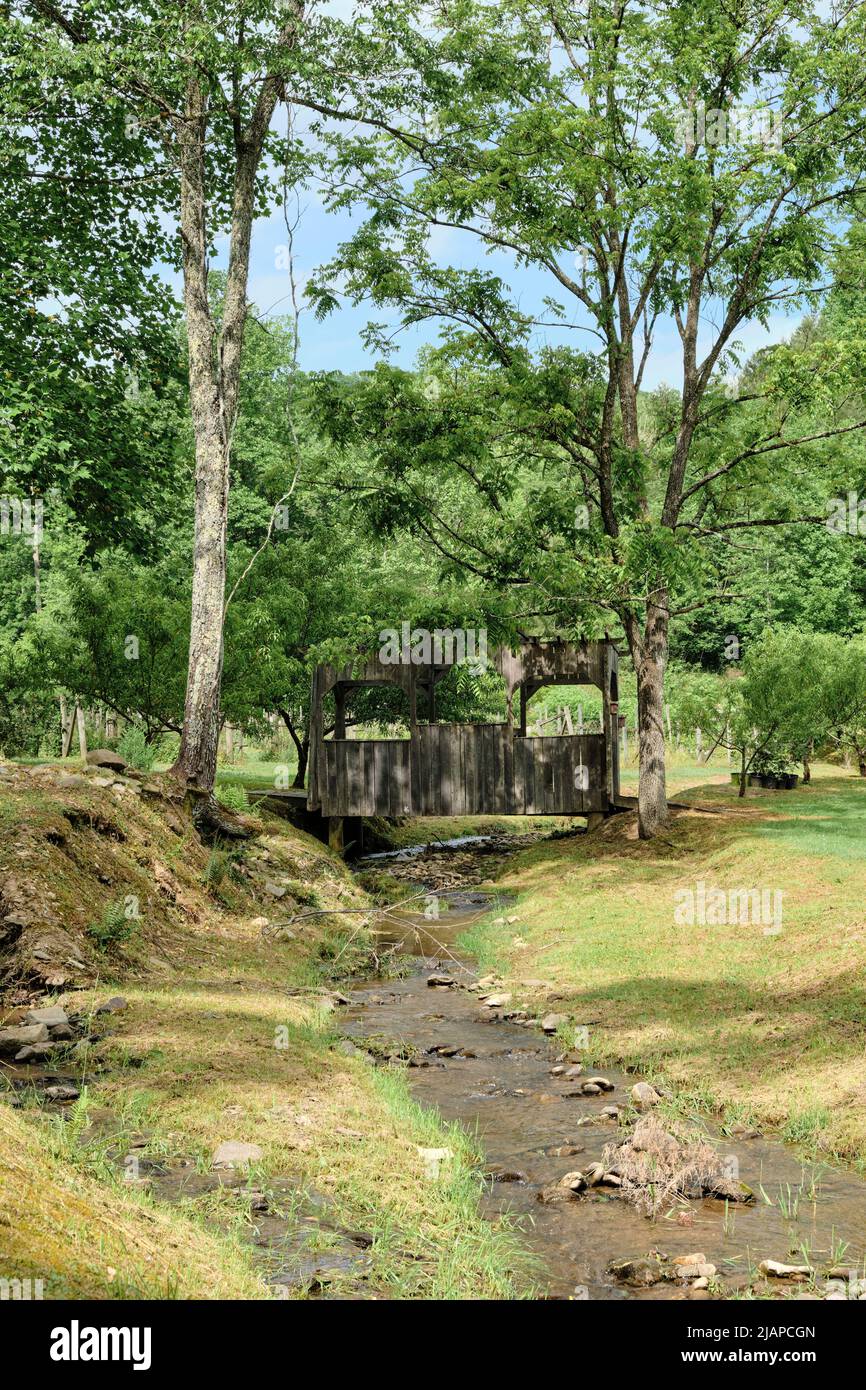 Kleine alte hölzerne überdachte Fußgängerbrücke über einen kleinen Bach im ländlichen Tennessee, USA. Stockfoto
