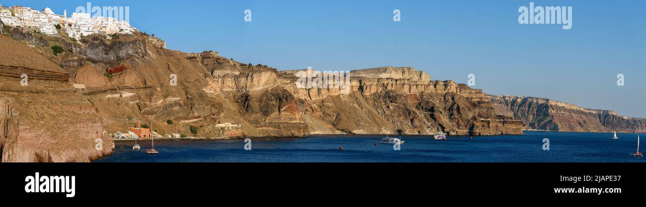 Panoramablick auf die Küste von Santorin. Griechenland. Santorini ist eine der Kykladen-Inseln in der Ägäis. Es wurde im 16.. Jahrhundert v. Chr. von einem Vulkanausbruch verwüstet, der die zerklüftete Landschaft für immer prägte. Die weiß getünchten, kubiformen Häuser der 2 Hauptstädte Fira und Oia Klammern sich an Klippen über einer Unterwasserkaldera (Krater). Sie blicken auf das Meer, kleine Inseln im Westen und Strände aus schwarzen, roten und weißen Lavakelben Stockfoto