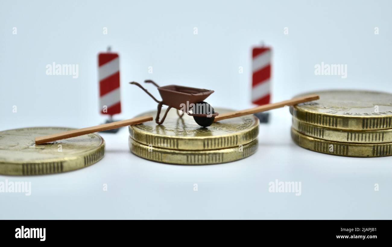 Das Konzept des Blockchain-Krypto-Währungsbergbaus umfasst Golddollar und Miniatur-Schubkarre, Planken und Gefahrenschilder oder steigende Baupreise Stockfoto