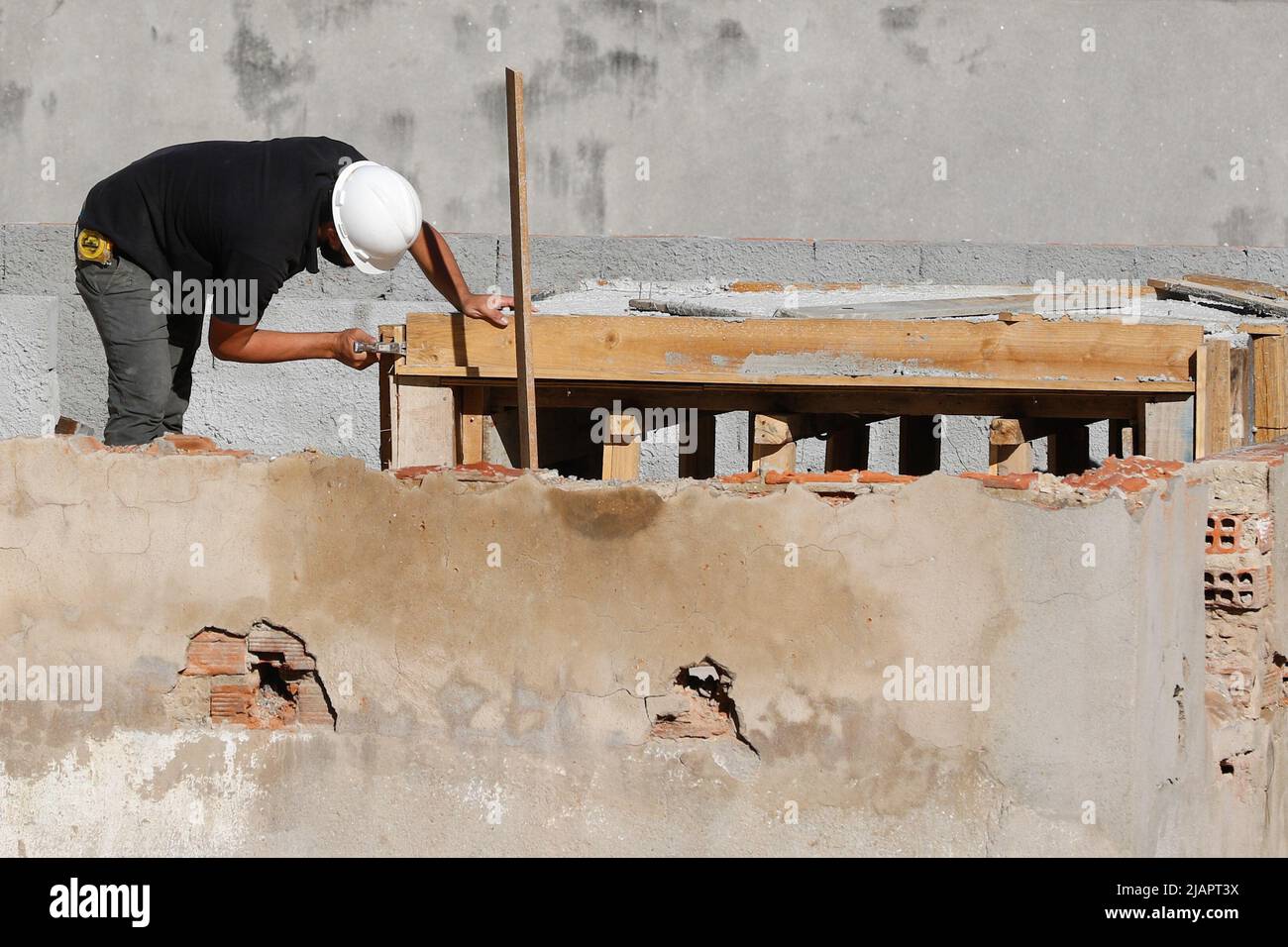 Zimmermann, Bauarbeiter. Arbeiter renovieren Dach des Gebäudes. Hausreparatur im Bau. Mann bei der Arbeit auf dem Dach. Stockfoto