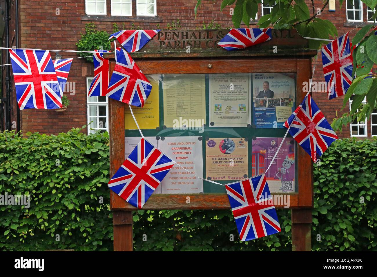 Queens Platin-Jubiläumsflaggen auf der Village Noticeboard, Broad Lane, Grappenhall Village, Warrington, Ceshire, UK, WA4 3ER Stockfoto