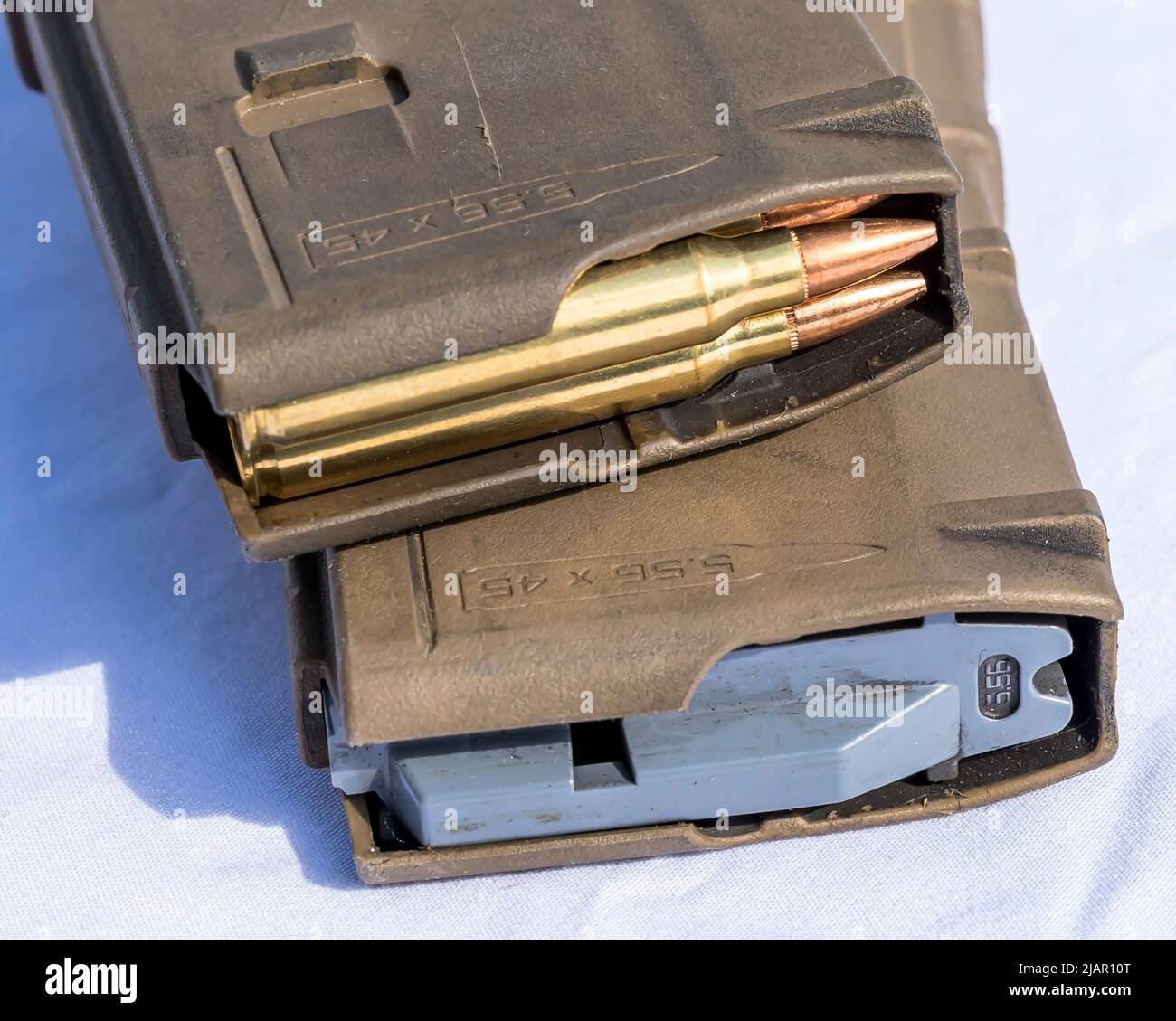 Zwei AR15 Magazine, eines mit Kugeln des Kalibers 223 und das andere leer auf weißem Hintergrund Stockfoto