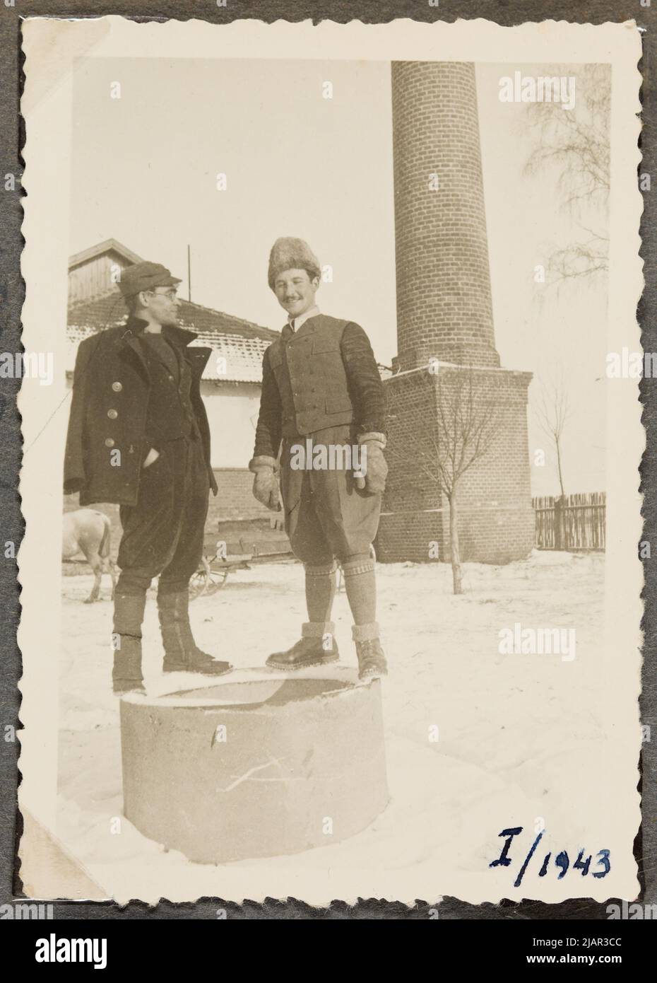 Zwei junge Männer stehen auf einem Betonkreis, im Hintergrund ein Fragment eines Gebäudes und eine Säule auf einem hohen Sockel. Kreis der Familie Stachiewicz Stockfoto