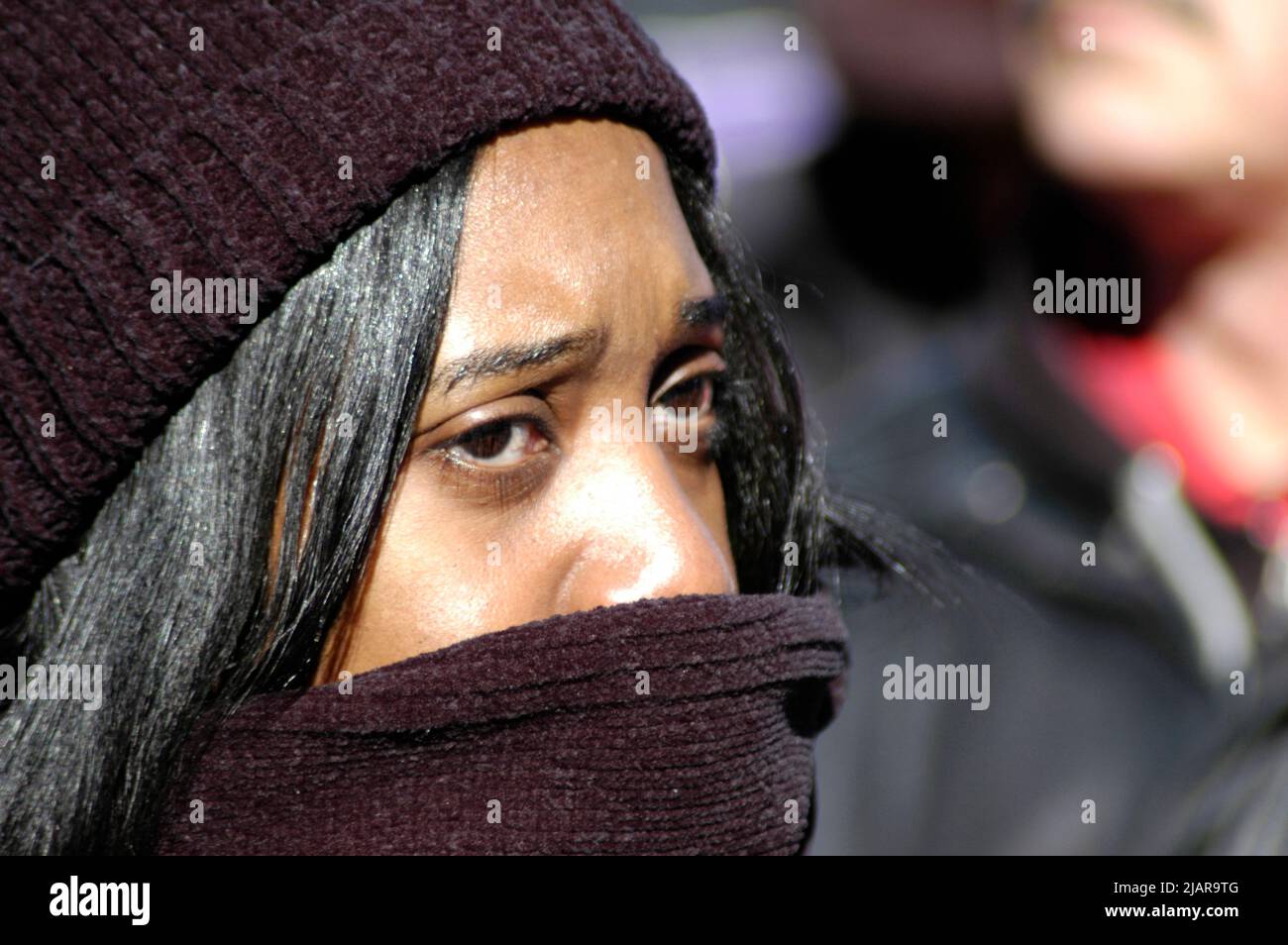 Junge ethnische schwarze Frau, die versucht, sich beim MLK-marsch zu Ehren von Martin Luther King in Atlanta warm zu halten Stockfoto