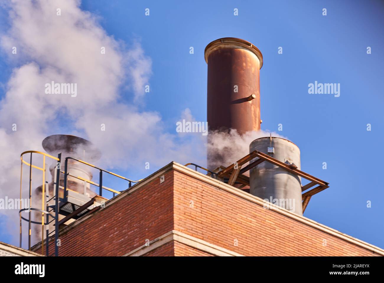 Industriekamin, der Dämpfe, Dampf und umweltschädliche Gase freisetzt Stockfoto