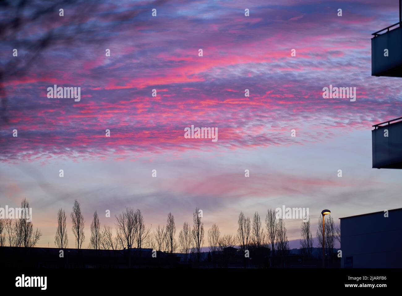 Dramatischer Blick auf den Himmel mit roten Wolken von der Stadt bei Sonnenuntergang Stockfoto