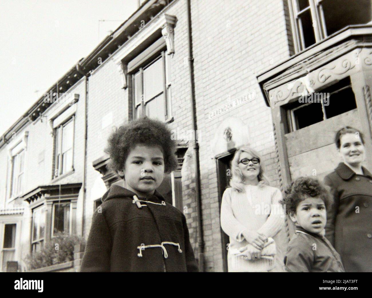 Zwei Frauen und zwei junge Jungen sehen sich 1972 eine Anti-Rassismus-Demonstration durch Leicester, England, Großbritannien und die Britischen Inseln an. Stockfoto