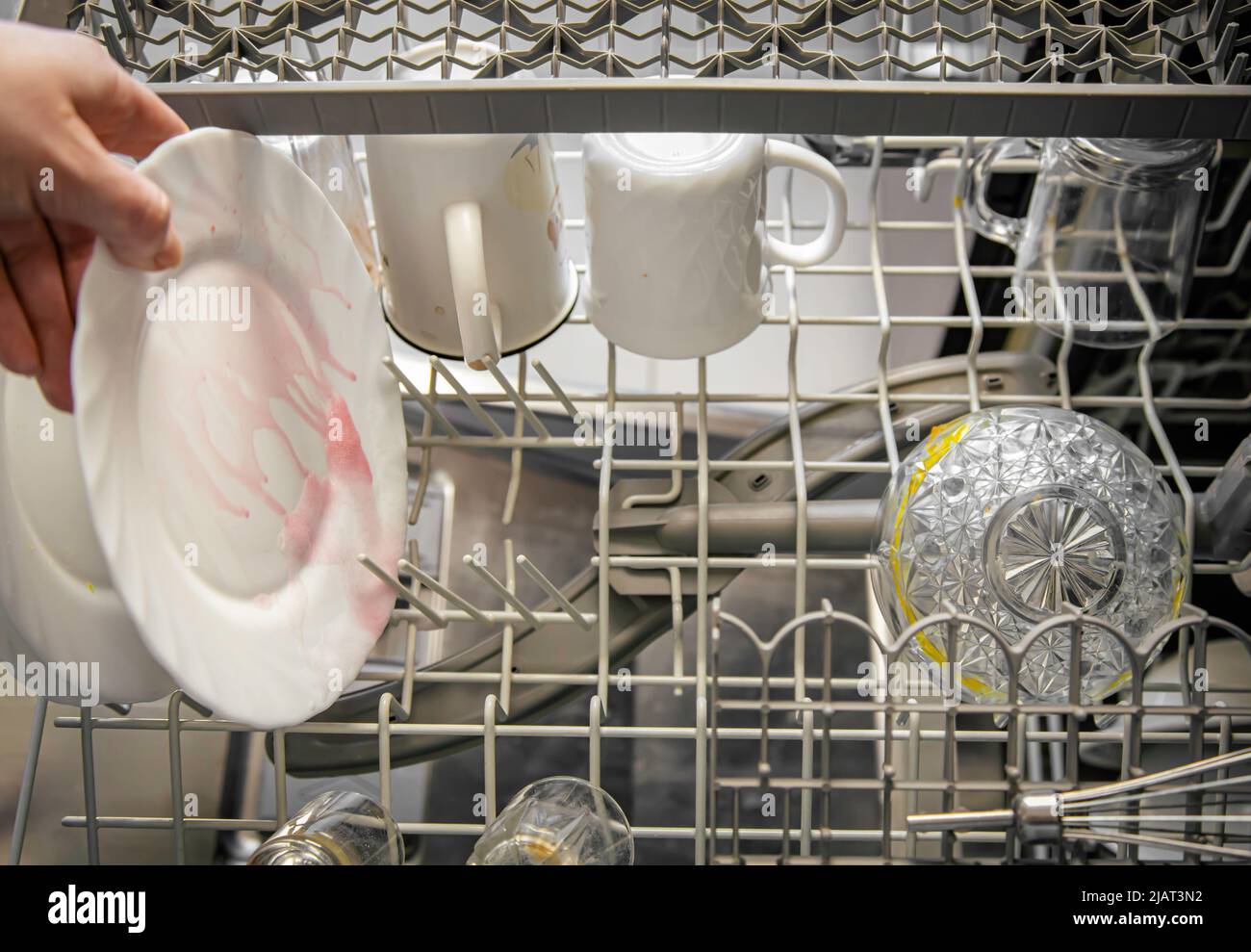 Schmutziges Geschirr im Geschirrspüler. Schmutziges Geschirr in den Geschirrspüler geben. Stockfoto