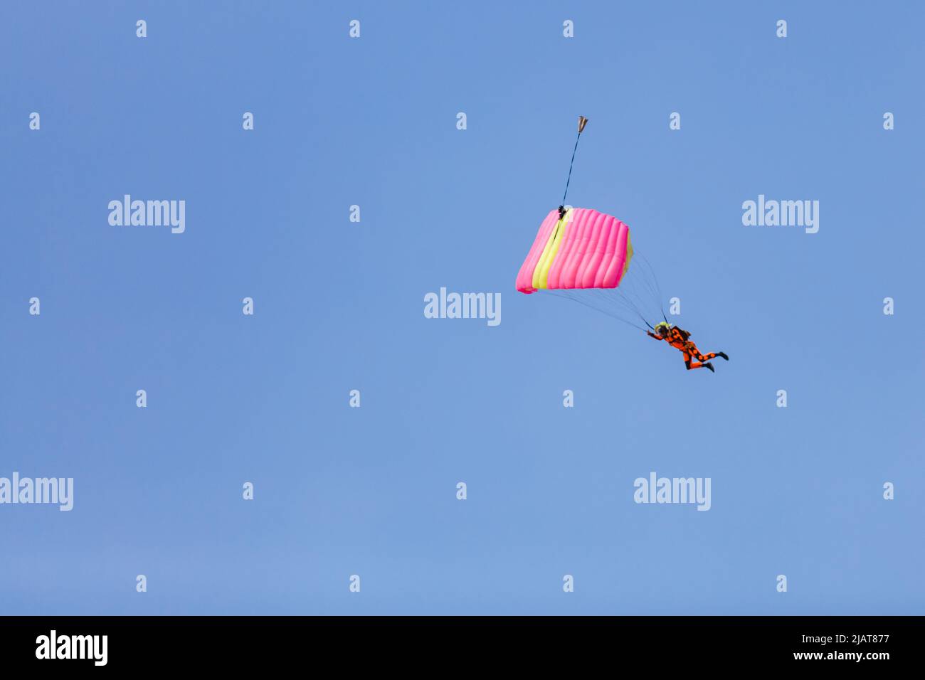 Fallschirmspringer mit einem kleinen Baldachin eines Fallschirms auf dem Hintergrund ein blauer Himmel, Nahaufnahme. Fallschirmspringer unter Fallschirm Stockfoto