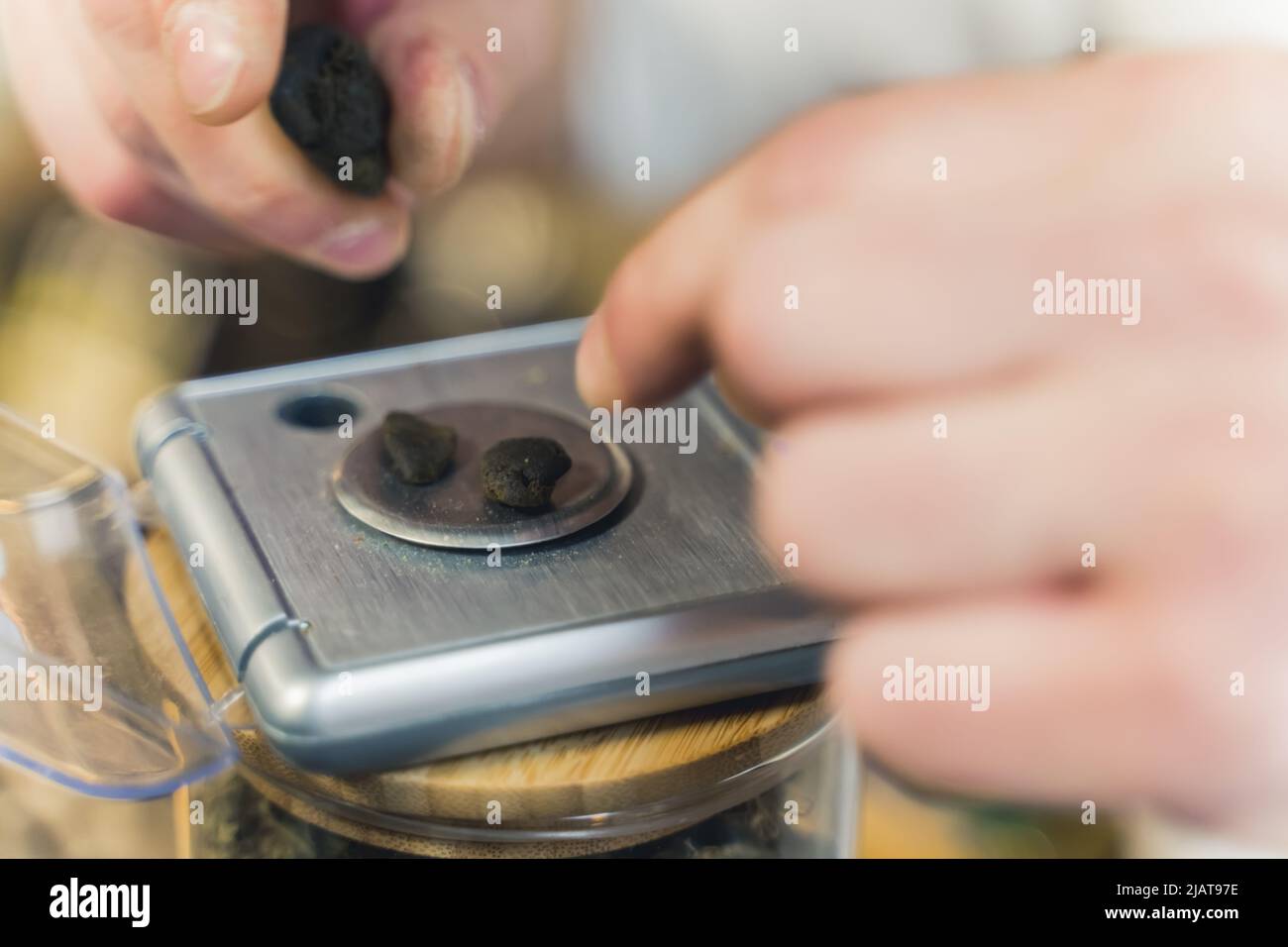 Kleine Stücke CBD-Haschisch auf einer Skala. Cannabisextrakt. Alternative Kräutermedizin Konzept. Hochwertige Fotos Stockfoto