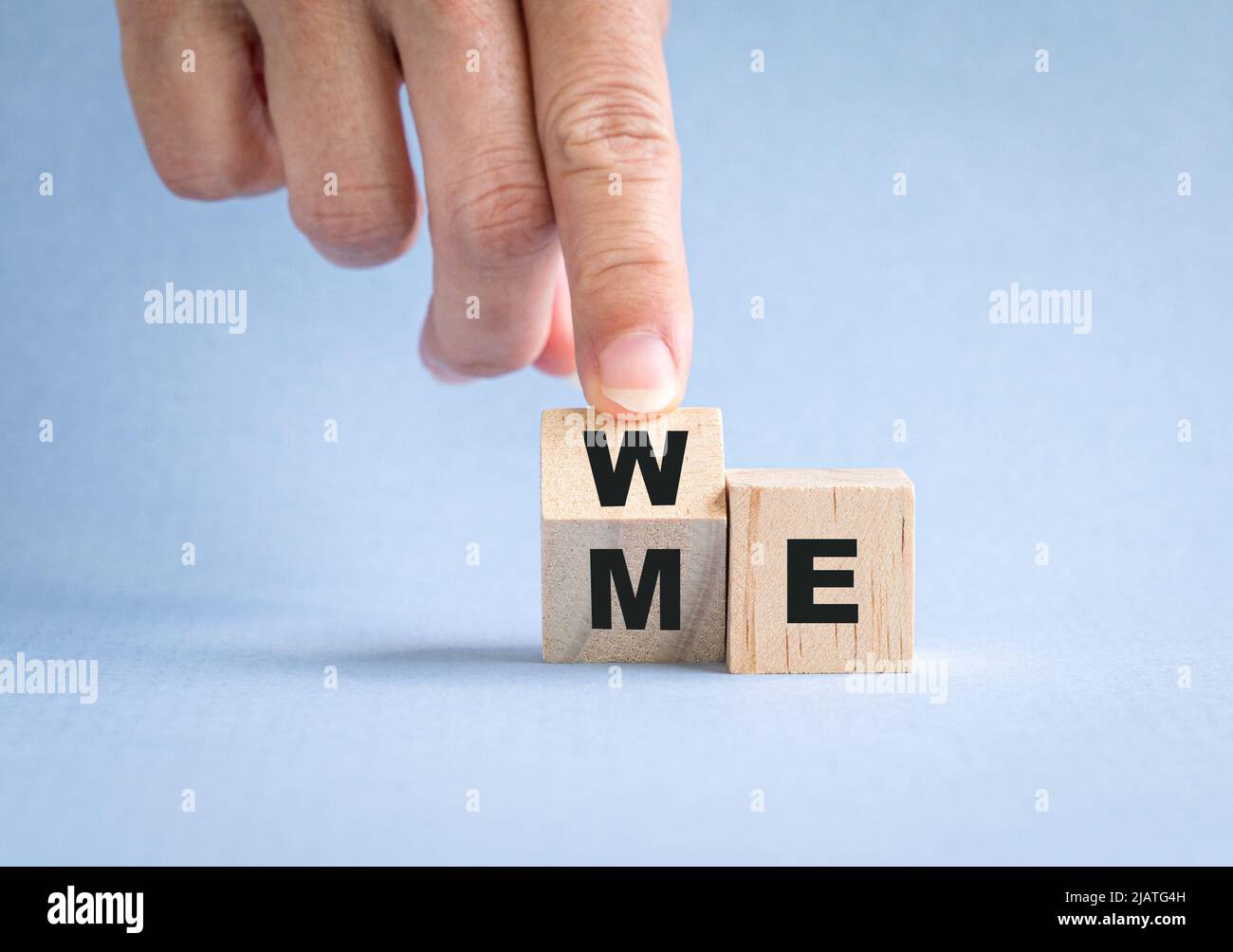Finger kippen Holzwürfel mit dem Wort mich zu uns. Teamwork-Konzept. Stockfoto