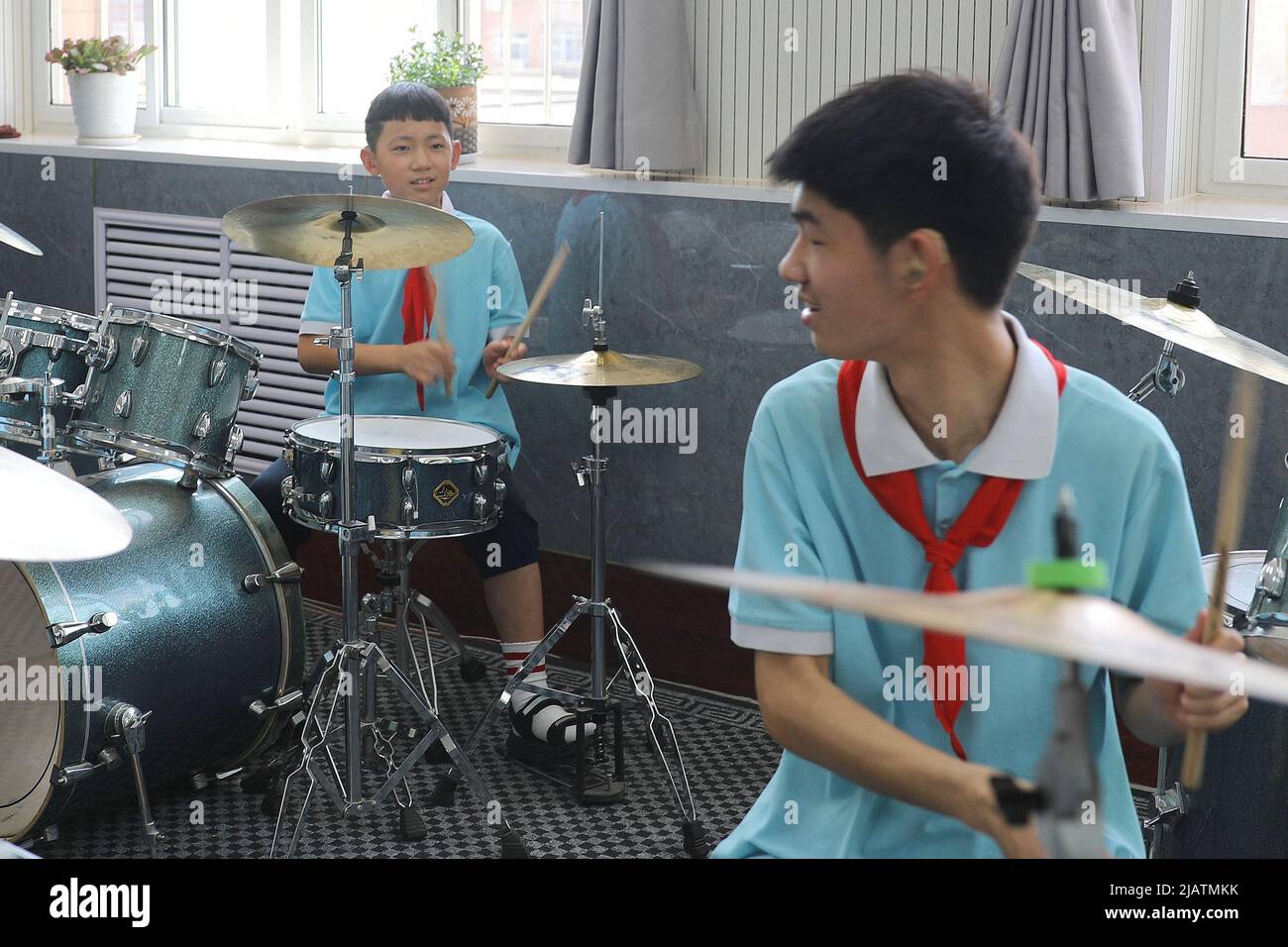 XINJI, 1. Juni 2022 (Xinhua) -- Zhao Kangtai (R) und sein jüngerer Bruder Zhao Kangyuan spielen das Schlagzeug im Musikunterricht der Xinji Spezialerziehungsschule in Xinji, nordchinesische Provinz Hebei, 31. Mai 2022. In der städtischen Spezialschule der Stadt Xinji, Provinz Hebei, schlägt eine Jazz-Trommler-Band namens „Against the Wind“ hoffnungsvolle Beats in der Welt der Stille. Die im Dezember 2018 gegründete Band beherbergt 10 Studenten mit Hörbehinderung oder geistiger Behinderung. Die Band wird seit ihrer Gründung und dem Ende systematisch und hart trainiert Stockfoto