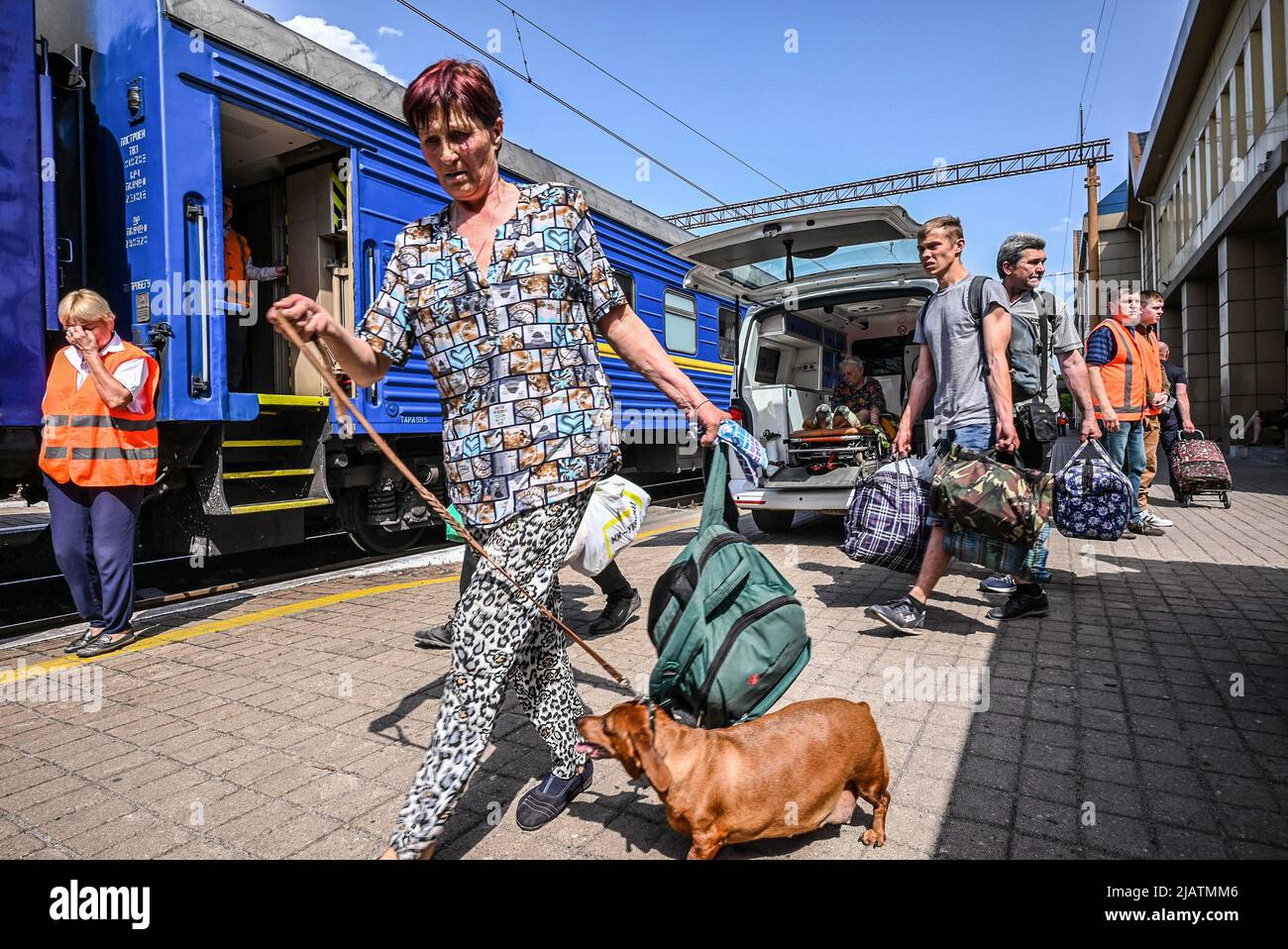 Die Leute sahen mit ihrem Gepäck und einem Hund einen Zug nehmen, um nach Dnipro zu evakuieren. Pokrovske ist eine kleine Stadt in der Region Donezk und ist die wichtigste Stadt, um Zivilisten mit dem Zug nach Dnipro zu evakuieren. Jeden Tag werden Hunderte von Zivilisten, die aus den Konfliktgebieten der Region evakuiert wurden, von Freiwilligen zum Bahnhof gebracht, die ihnen helfen, in Züge zu steigen und in sicherere Gegenden des Landes zu ziehen. Viele von ihnen sind ältere Menschen aus kleinen Dörfern in Kampfgebieten und benötigen Hilfe wegen ihres zerbrechlichen Zustands. Stockfoto