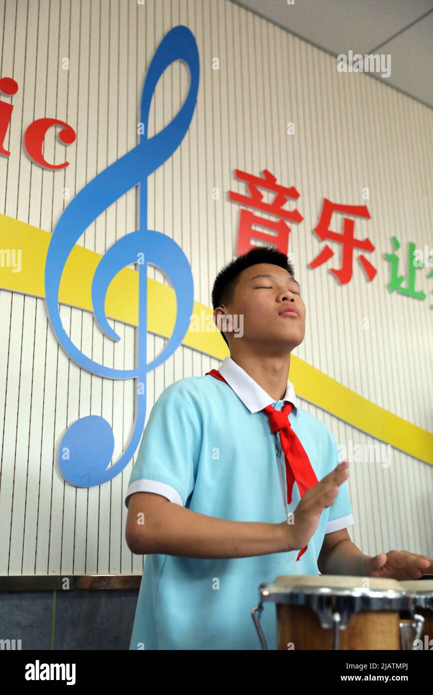 XINJI, 1. Juni 2022 (Xinhua) -- der Student Liu Junhong praktiziert Schlagzeug im Musikklassenzimmer der Xinji Spezialschule in Xinji, nordchinesische Provinz Hebei, 31. Mai 2022. In der städtischen Spezialschule der Stadt Xinji, Provinz Hebei, schlägt eine Jazz-Trommler-Band namens „Against the Wind“ hoffnungsvolle Beats in der Welt der Stille. Die im Dezember 2018 gegründete Band beherbergt 10 Studenten mit Hörbehinderung oder geistiger Behinderung. Die Band wird seit ihrer Gründung systematisch und hart trainiert, und die Bemühungen haben sich gelausgezahlt, als die Band auflief Stockfoto