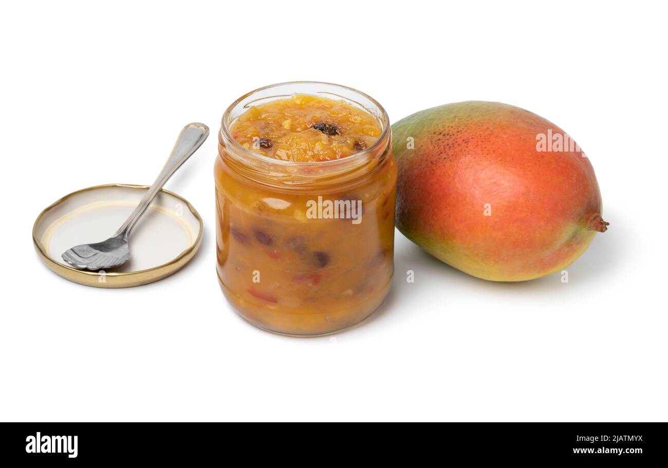 Glas mit hausgemachtem Mango-Chutney und einer frischen Mango isoliert auf weißem Hintergrund Stockfoto