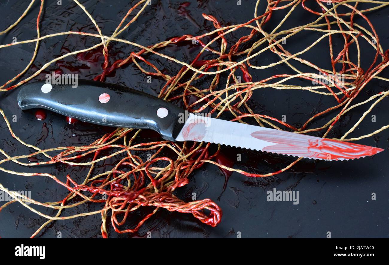 Blutiges Verbrechensmesser mit Fäden Stockfoto