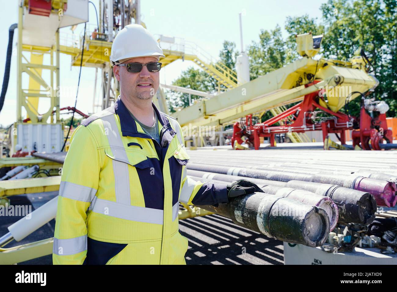 Graben Neudorf, Deutschland. 01.. Juni 2022. Sebastian Homuth, Bohrbeaufsichtsleiter am geothermischen Bohrstandort der Deutschen Erdwärme, steht neben den Bohrrohren am Bohrgerät. Das Entwicklungsprojekt in Graben-Neudorf ist derzeit das fortschrittlichste Projekt der Deutschen Erdbeere. Quelle: Uwe Anspach/dpa/Alamy Live News Stockfoto