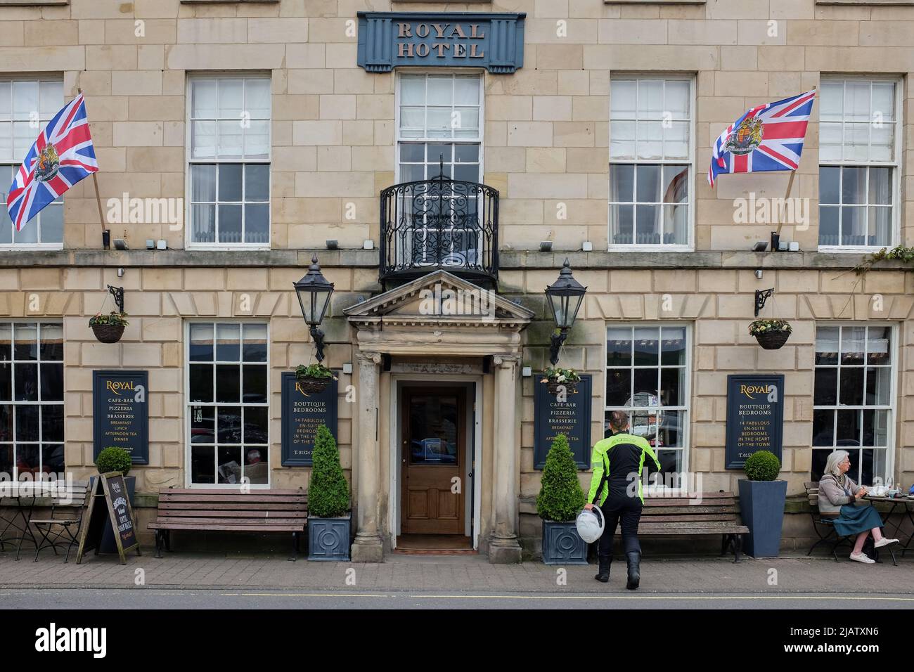 Motorradfahrer, die zum Royal Hotel laufen, wo die Unionsflagge in Erwartung des bevorstehenden königlichen Jubiläums zum Gedenken an 70 Jahre fliegt Stockfoto