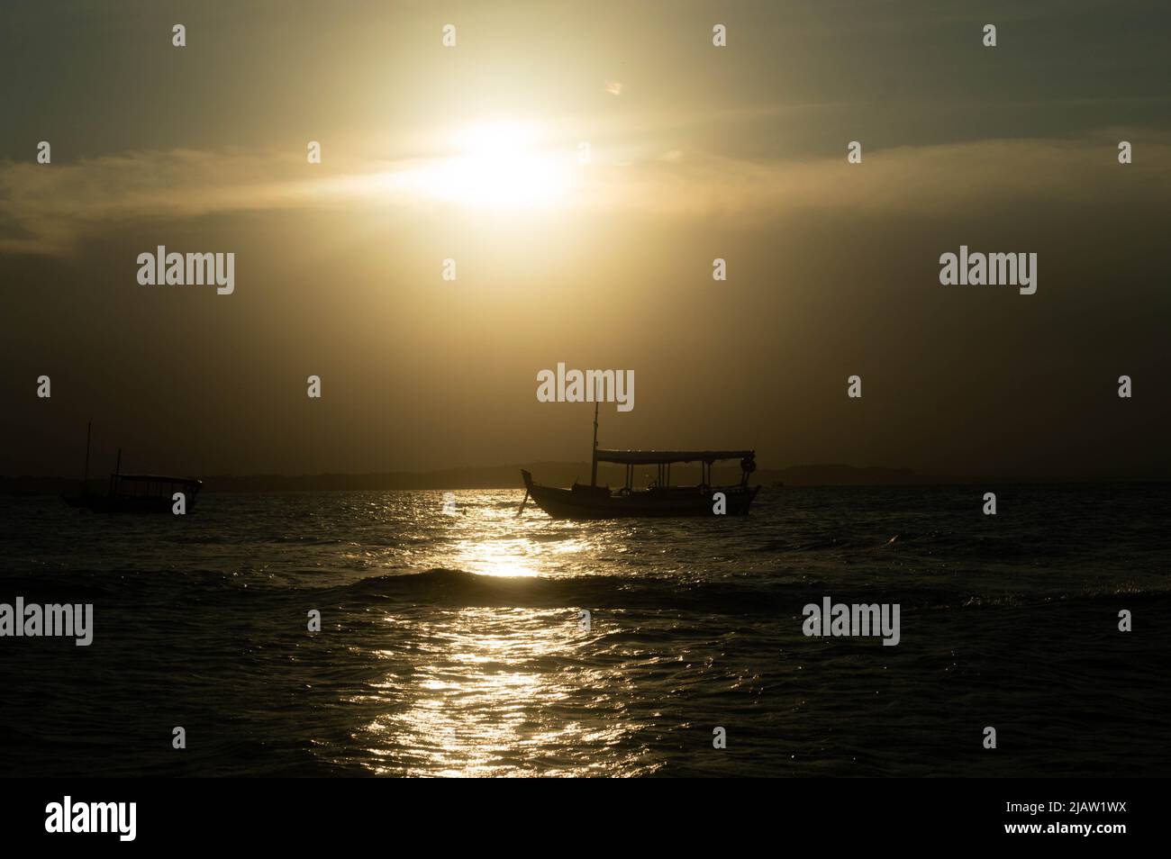 Boot in Sonnenuntergangslandschaft im Meer Stockfoto