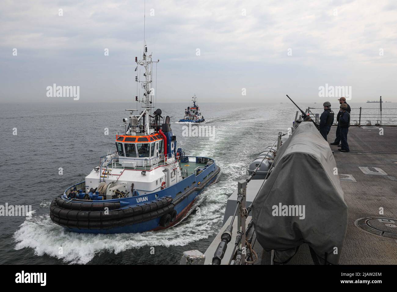 220505-N-ED646-0215- GDYNIA, Polen (5. Mai 2022) Seeleute an Bord der Arleigh Burke-Klasse, USS Gravely (DDG 107), schauen nach, während die polnischen Schlepper Uran und Fairplay VII neben dem Schiff fahren, während sie sich darauf vorbereiten, nach Gdynia, Polen, für einen planmäßigen Hafenbesuch, den 5. Mai 2022, zu fahren. Gravely wird mit der Harry S. Truman Carrier Strike Group im Rahmen eines geplanten Einsatzes im Einsatzgebiet der Sechsten Flotte der USA eingesetzt, um die Interessen der USA, der Alliierten und der Partner in Europa und Afrika zu unterstützen. (USA Navy Foto von Mass Communication Specialist Seaman Moises Sandoval) Stockfoto