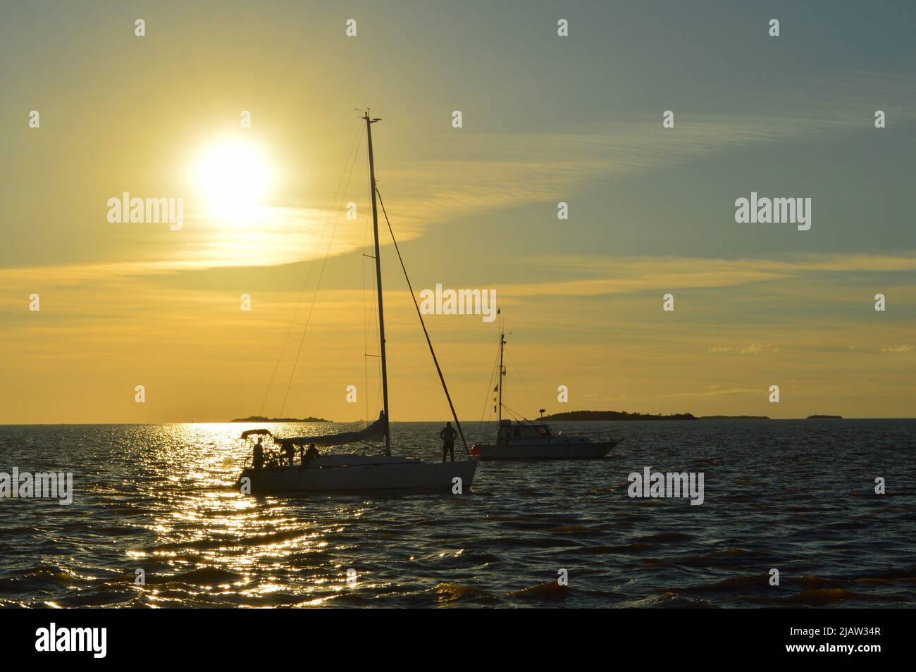 Segelboot in Sonnenuntergangslandschaft auf dem Fluss Stockfoto
