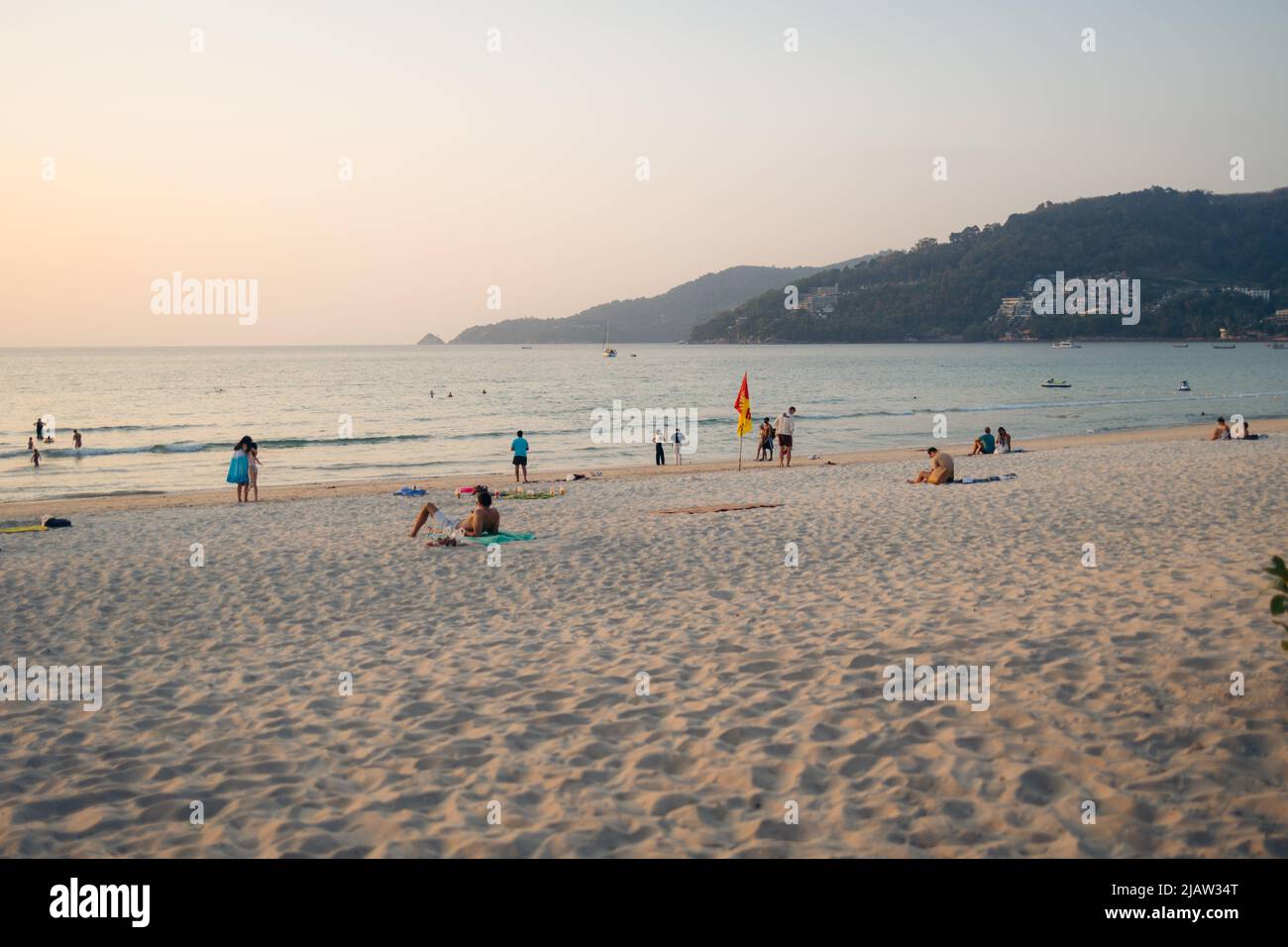 Strand voller Menschen, die den Sonnenuntergang in Phuket, Thailand, genießen Stockfoto