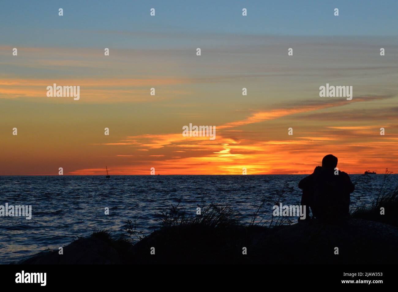 Sonnenuntergang auf dem Fluss mit einer Person im Hintergrund Stockfoto