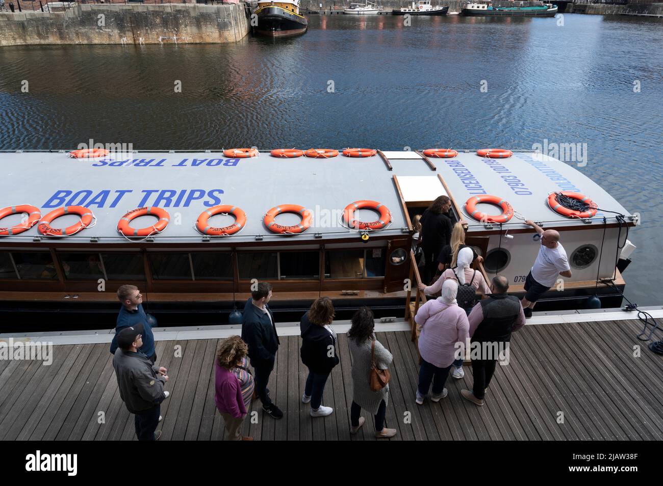 Liverpool, England, Großbritannien. Besucher warten darauf, an Bord eines Bootes zu gehen, um auf dem Fluss Mersey zu fahren. Stockfoto
