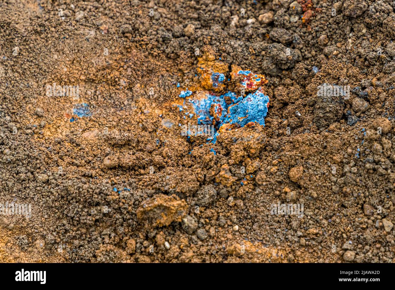 Der Boden im Laugarvatn Fontana-Bad in Island zeigt hier lebhafte blaue und orangefarbene Mineralablagerungen, ein Beweis für die geothermische Aktivität unter der Oberfläche. Stockfoto