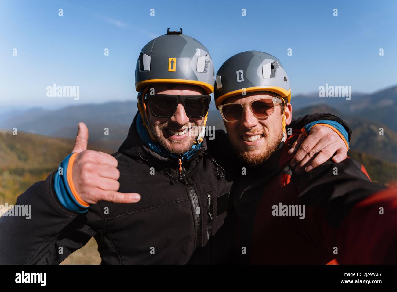 Portrait von zwei Gleitschirmen, die sich auf den Flug am Berg vorbereiten, mit Blick auf die Kamera. Extreme sportliche Aktivitäten. Stockfoto