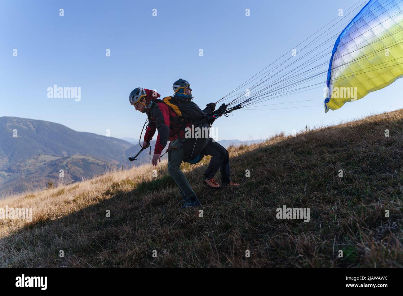 Gleitschirme bereiten sich auf den Flug in den Bergen vor. Extreme sportliche Aktivitäten. Stockfoto