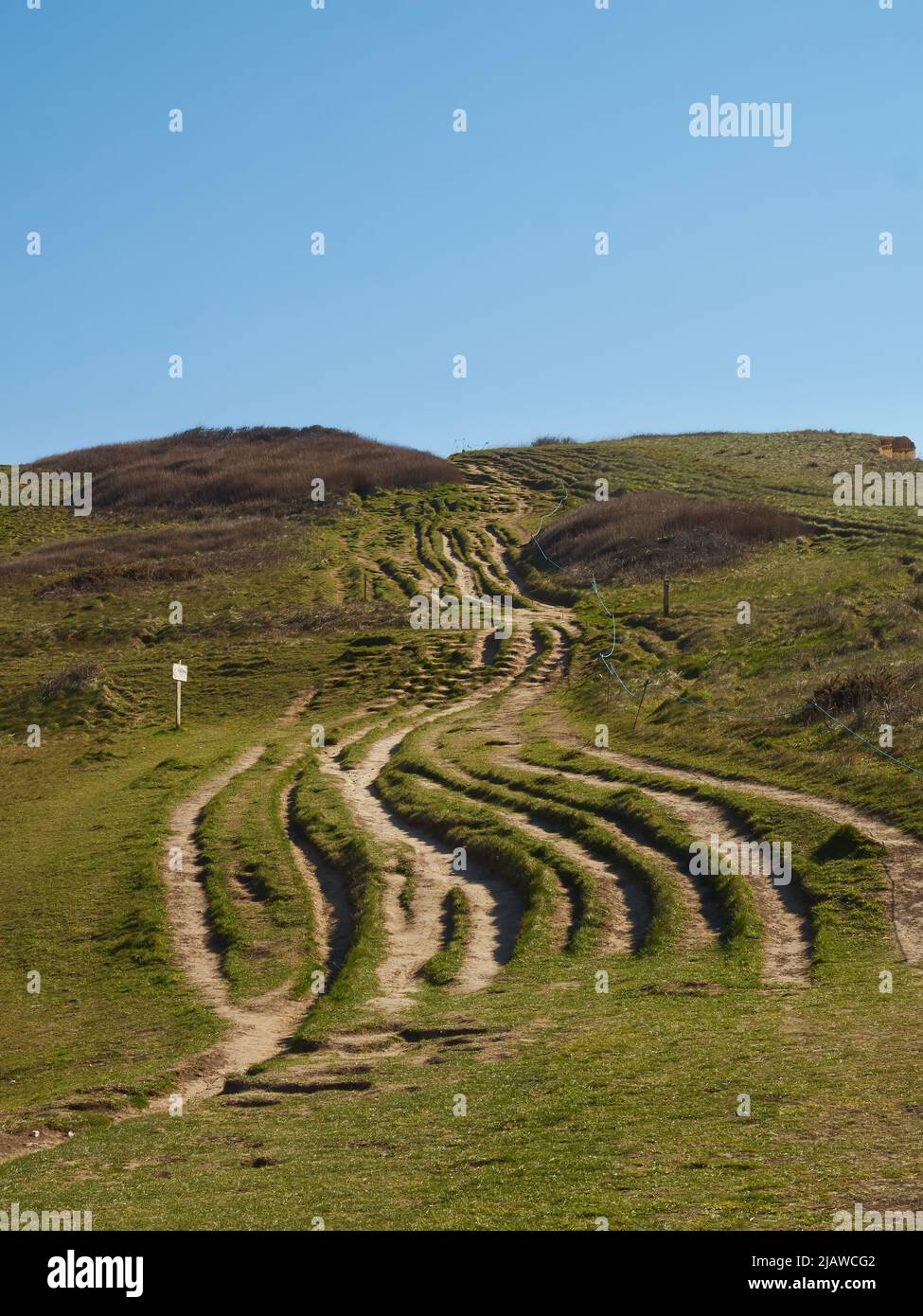 Ein Blick auf eine steile Klippe, die die gewundenen, gewundenen Serpentinen zeigt, die andere Wanderer im Laufe der Jahre auf ihrem Weg zum Gipfel einschlagen. Stockfoto