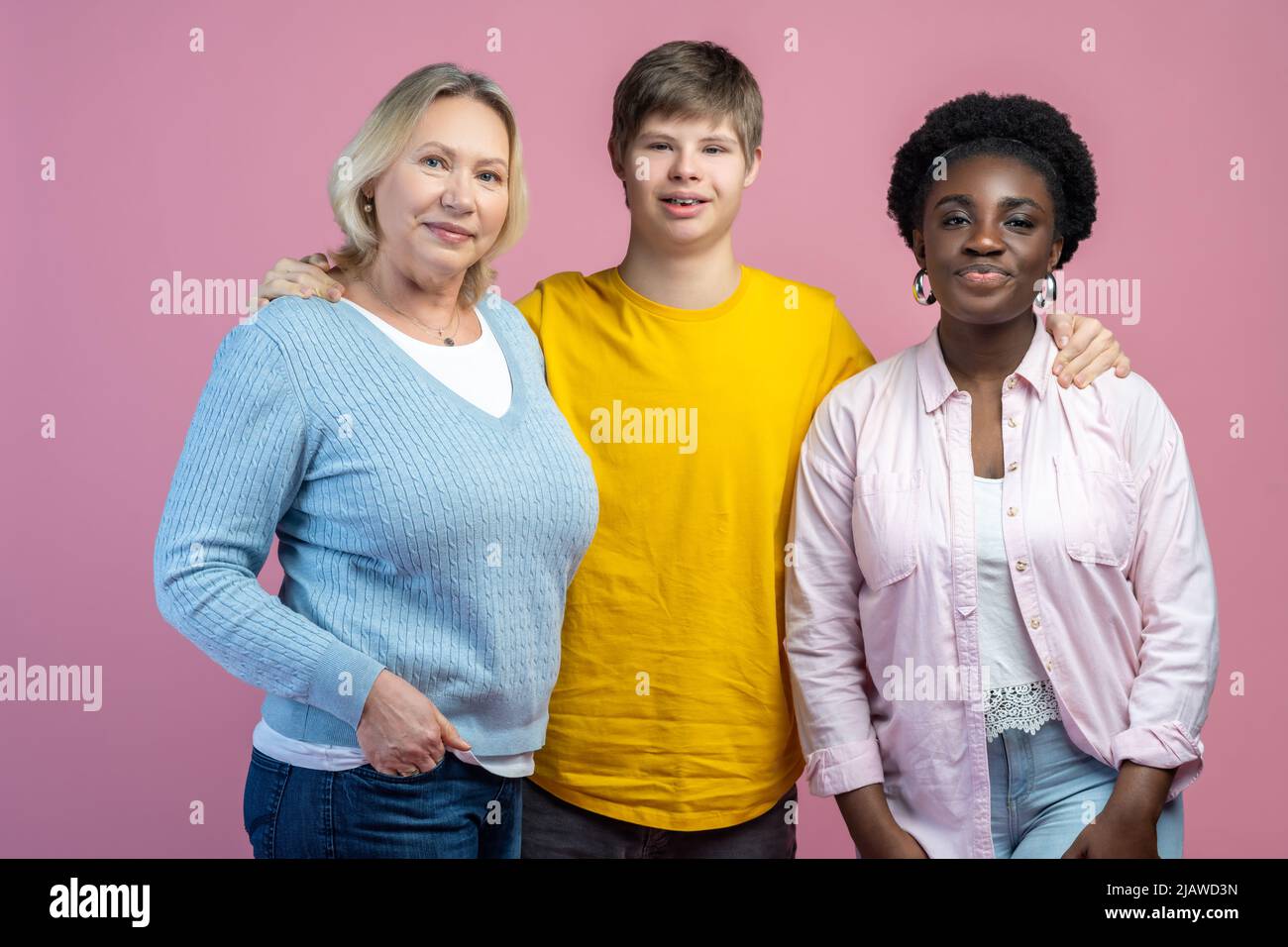 Guy umarmte zwei Frauen und schaute auf die Kamera Stockfoto