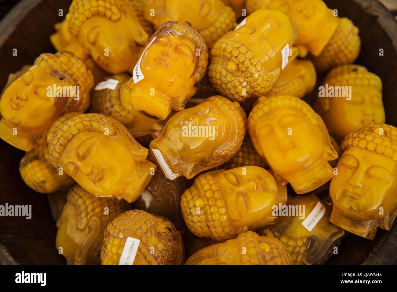 Kleine gelbe Buddha-Kopfskulpturen zum Verkauf auf dem Brimfield Flohmarkt, Massachusetts Stockfoto