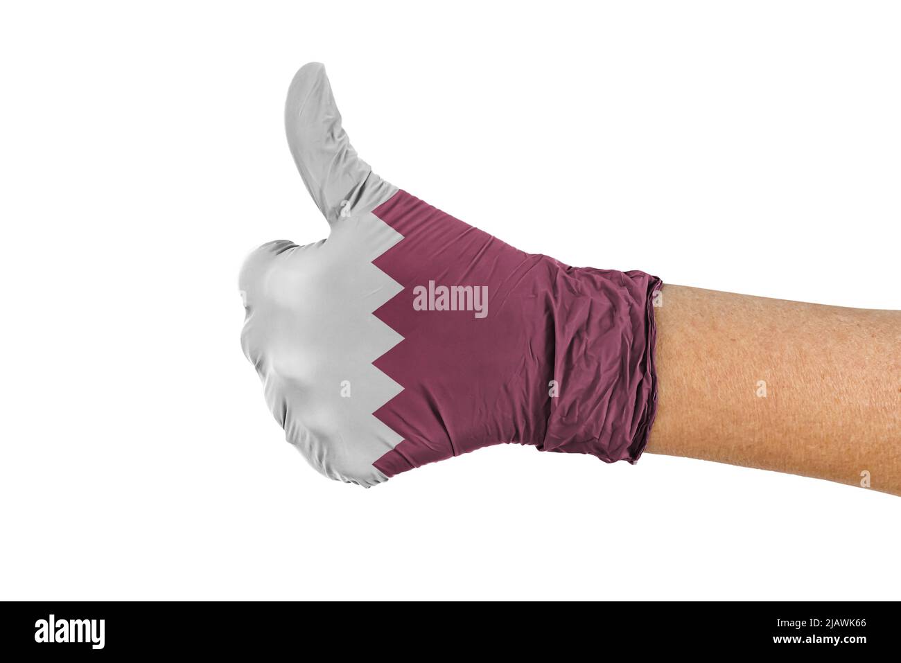 Die Flagge des Landes Katar auf einem Handschuh zeigt das Zeichen „Daumen hoch“ Stockfoto