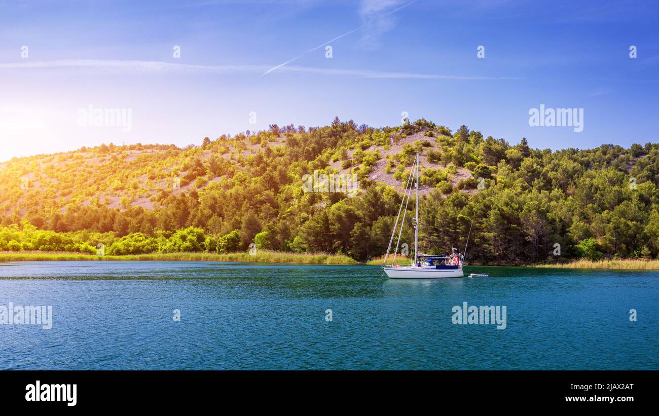 Segelboot im Meer in der Abendsonne mit Bergen im Hintergrund, Luxus Sommer Abenteuer, aktiven Urlaub im Mittelmeer, Kroatien. Segeln Stockfoto